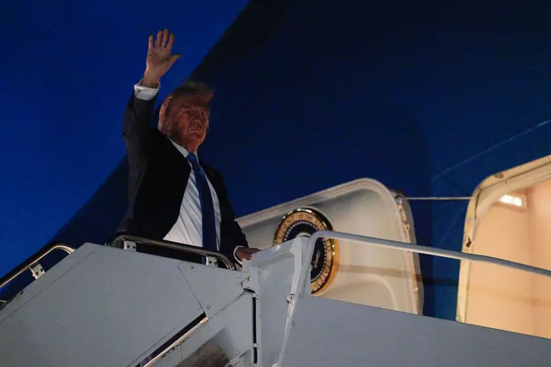 Trump saluda desde las escaleras del avión presidencial