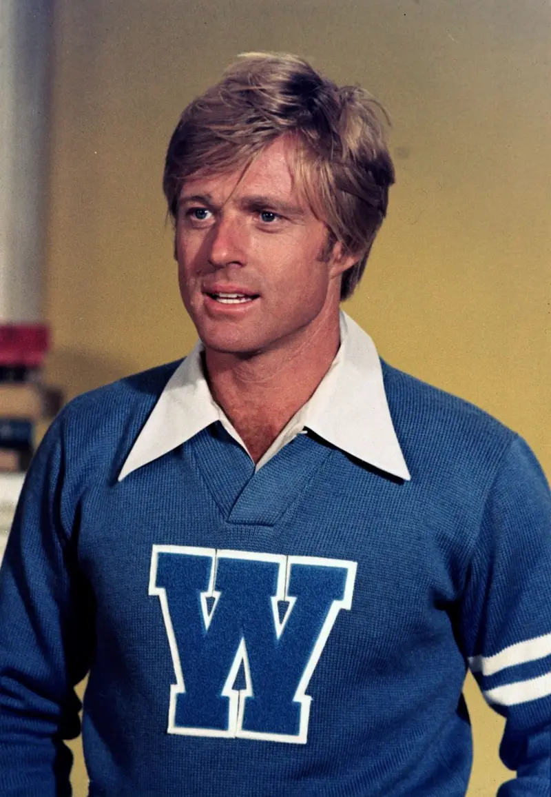 Robert Redford luciendo un suéter universitario con una W en el frente y un cuello blanco
