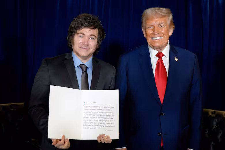 Javier Milei y Donald Trump posando juntos mientras sostienen un documento oficial