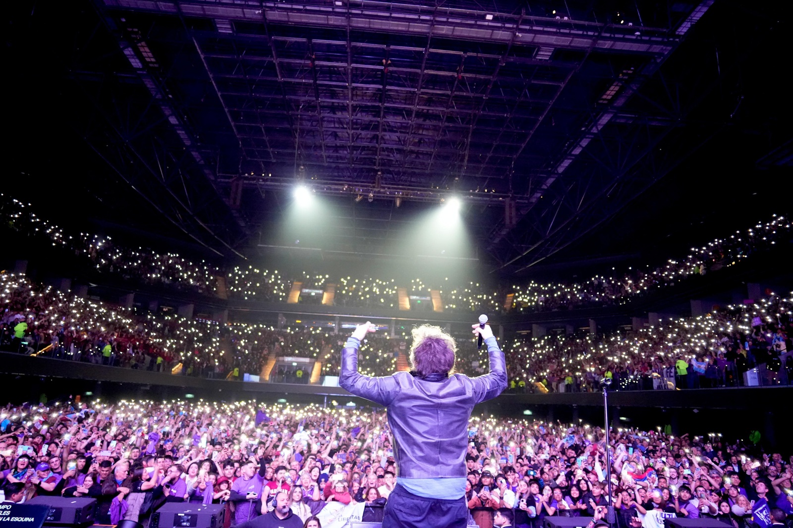 Público libertario con banderas violetas en el Movistar Arena durante el show de Javier Milei.