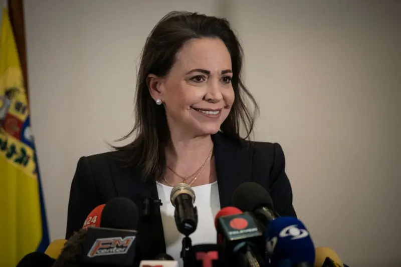 María Corina Machado sonríe delante de micrófonos durante una conferencia de prensa