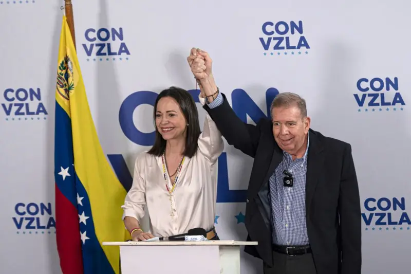 María Corina Machado alzando la mano de Edmundo González