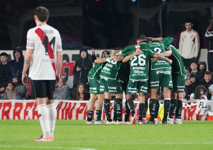 Jugadores de Sarmiento celebran el gol ante River con un abrazo grupal.