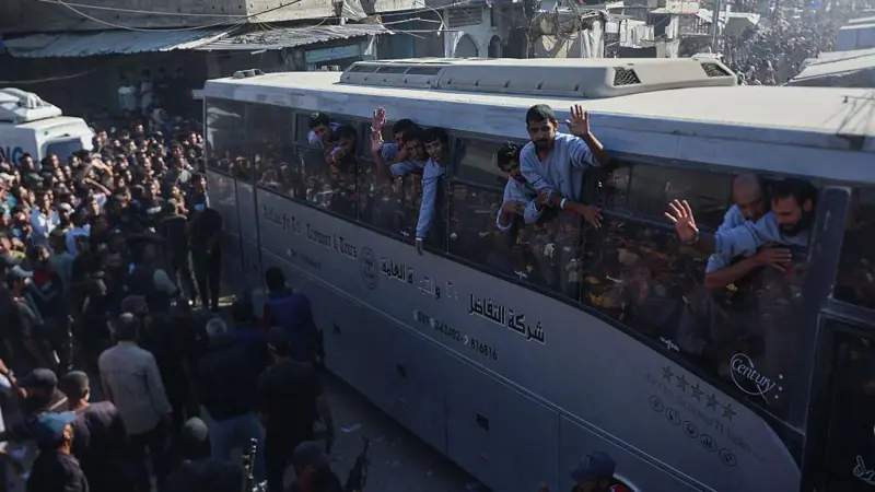 Palestinos liberados saludan desde un autobus.