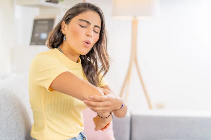 Una mujer tomándose el codo.