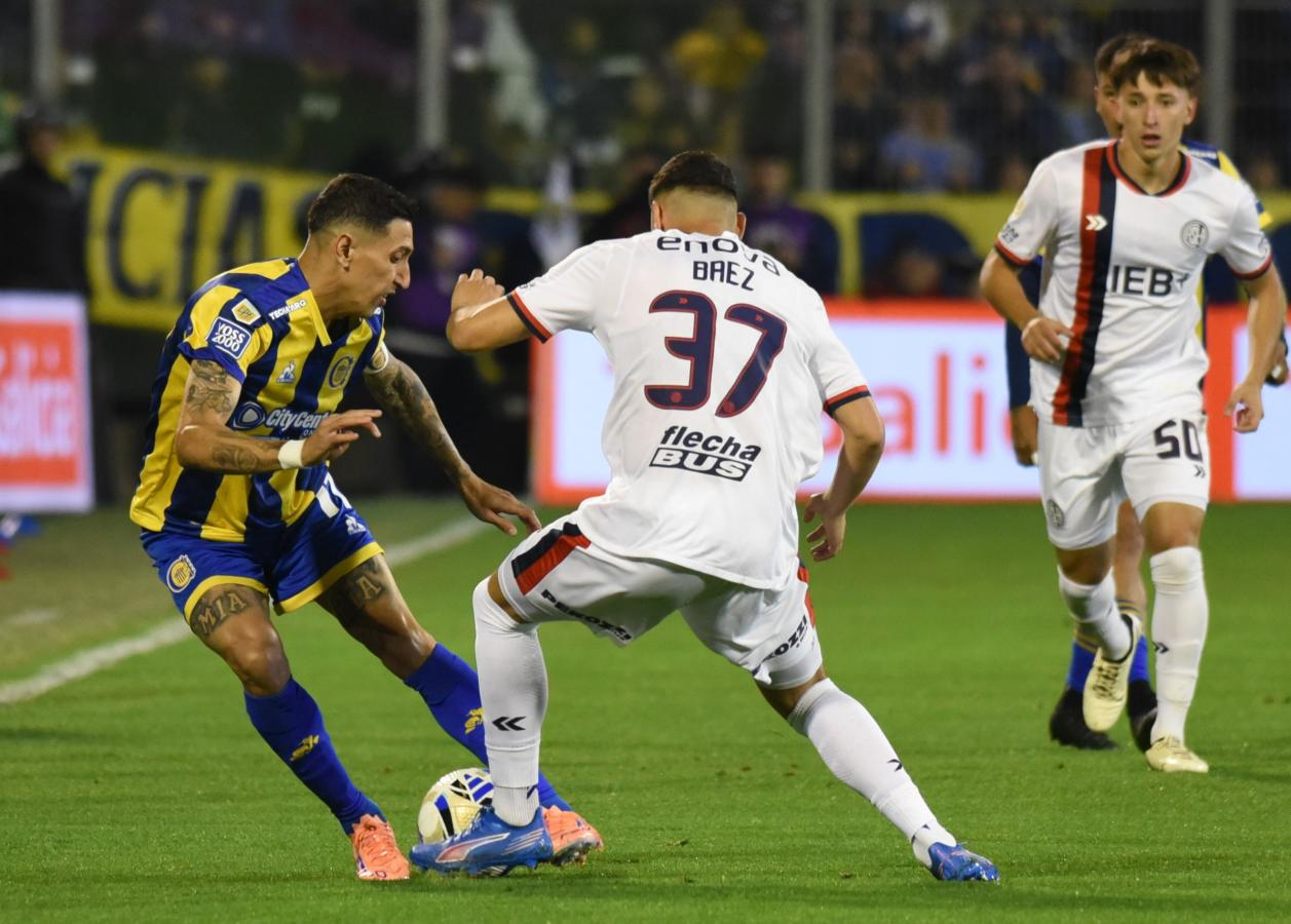 Ángel Di María conduce la pelota e intenta eludir a un defensor de San Lorenzo durante el partido en el Gigante de Arroyito.