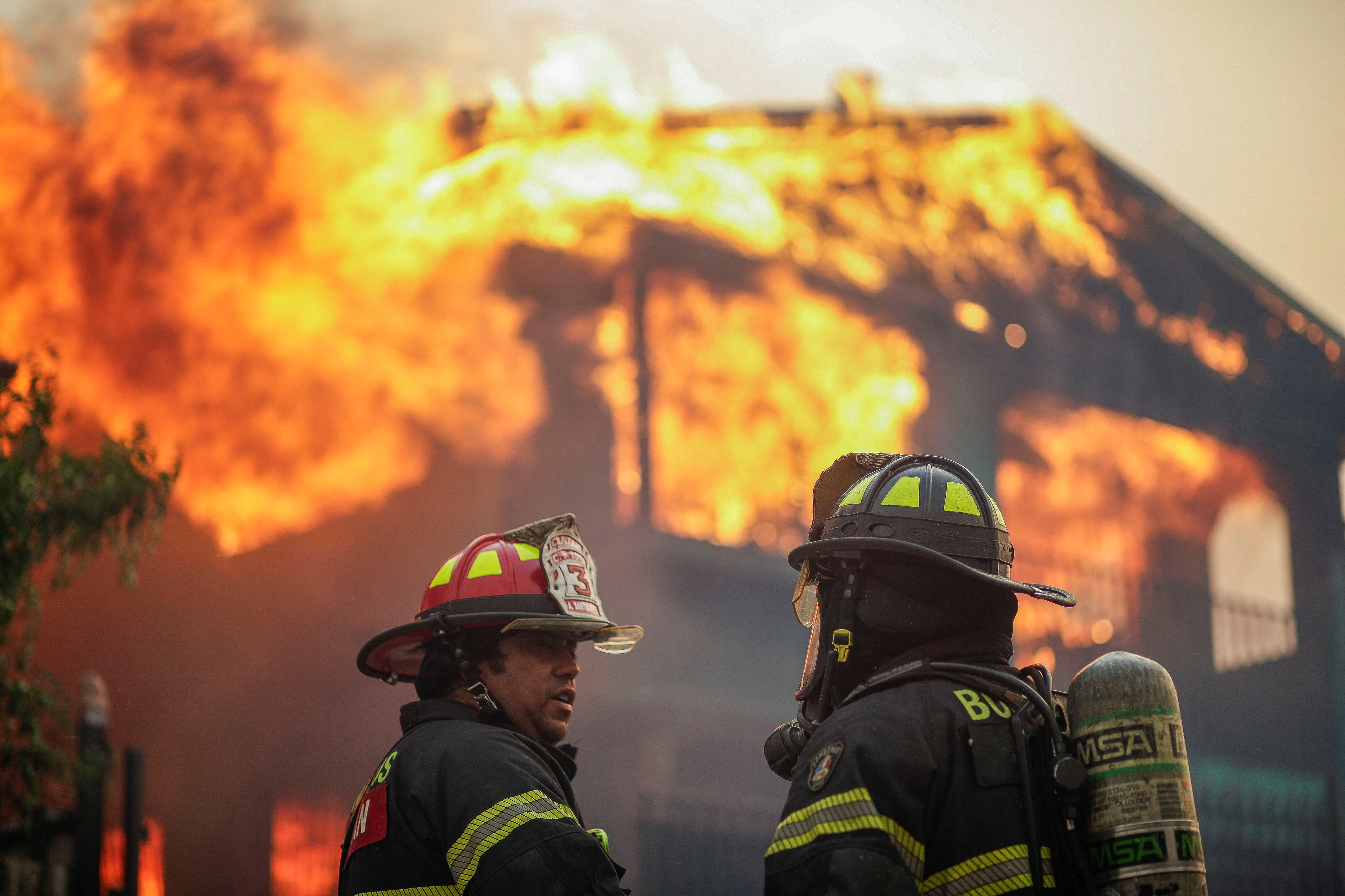 Bomberos combaten un incendio que consume una vivienda durante la emergencia forestal en Chile