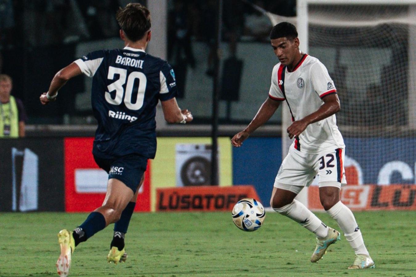 Jugador de Talleres y futbolista de San Lorenzo disputan la pelota durante el partido por la Fecha 8 del Torneo Apertura.